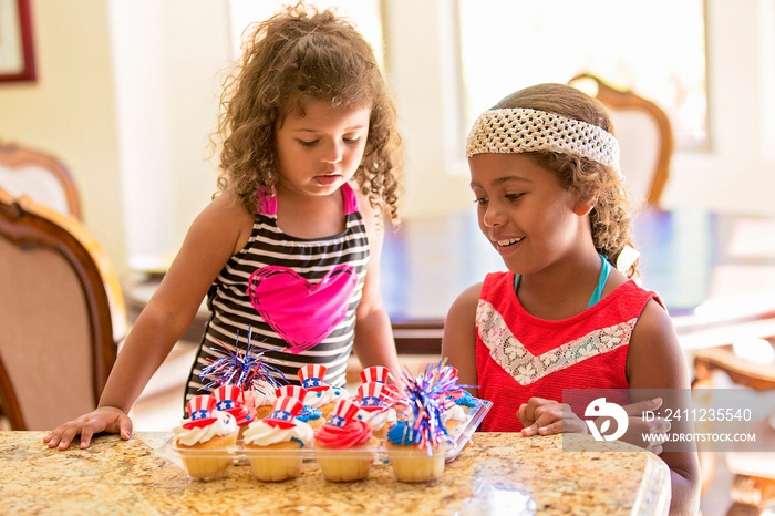 Girls looking at american flag theme decorated cupcakes