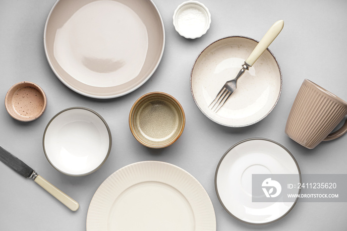 Different clean dishware on grey background