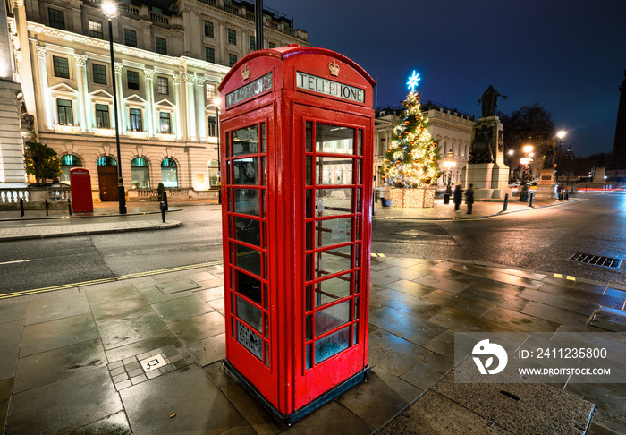 Christmas time in London: a red telephone booth in front of an illuminated Christmas Tree in Central