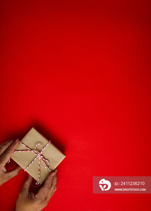 Male hands holding red gift on red background