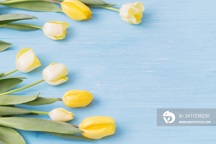 yellow tulips on wooden background