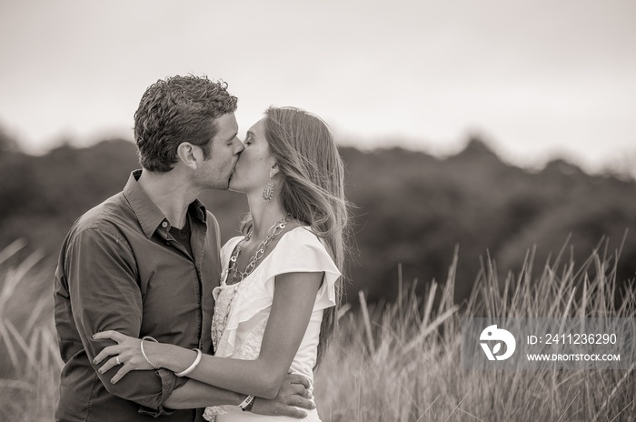 Grayscale shot of a couple in love kissing each other passionately