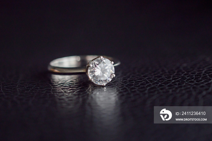 Close up diamond ring jewelry on black leather background