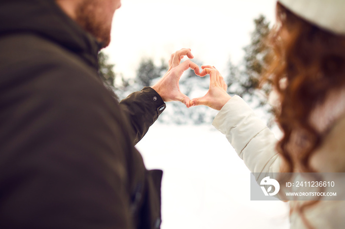 Man and woman making heart symbol with hands