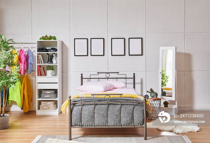 Metal bedstead in the bed room, white wall background, frame, wardrobe, clothes and blanket style.