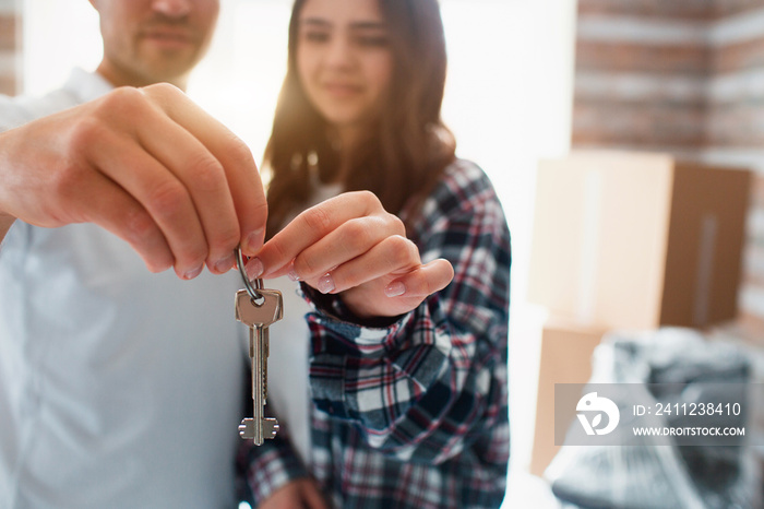 Close-up of keys in hands concept. Young couple first time home owners celebrate moving day concept,