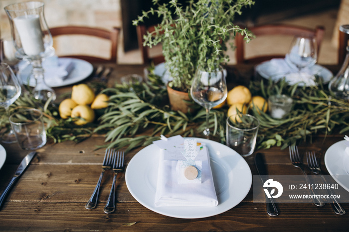 in the back yard of the old villa there is a long festive table, which is decorated with lemons and 