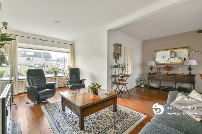 Interior of living room with comfortable sofa and TV against windows in contemporary apartment