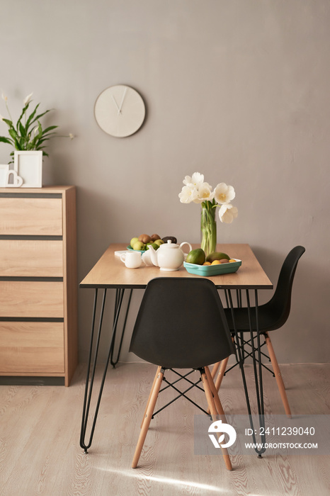 Loft style dining room. Dining table with chairs. Mock up interior photo. Black chairs at dining tab