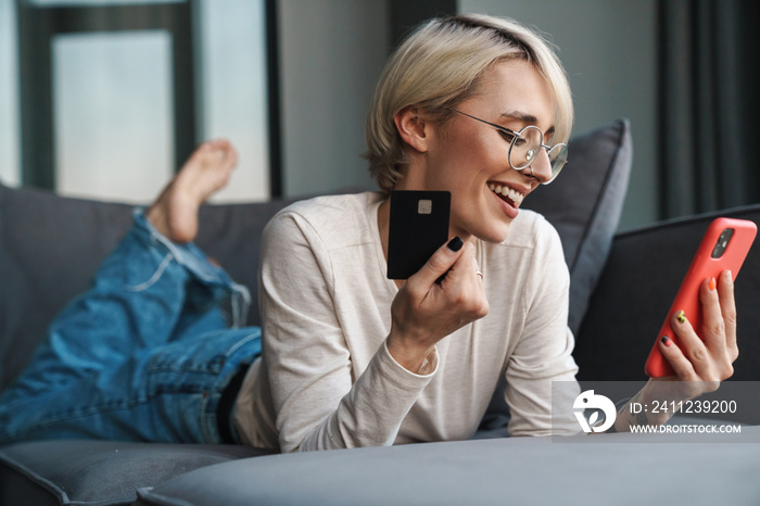 Smiling blonde mid aged woman shopping online