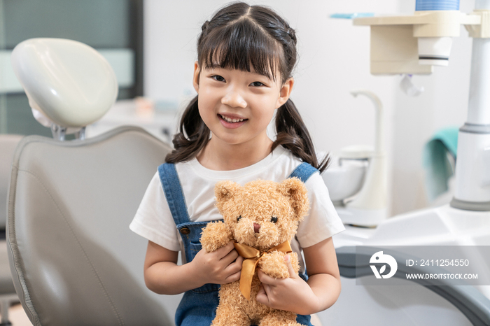 小女孩在牙科诊所拿着泰迪熊