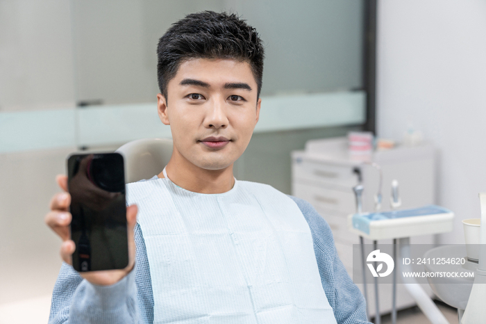 病人在牙科诊所展示手机