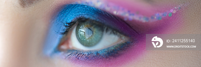 Bright blue eye makeup with sparkles closeup