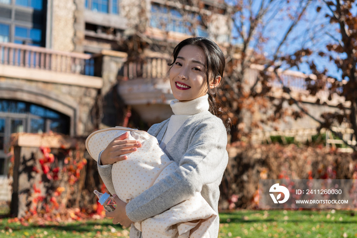 年轻母亲推着婴儿车散步