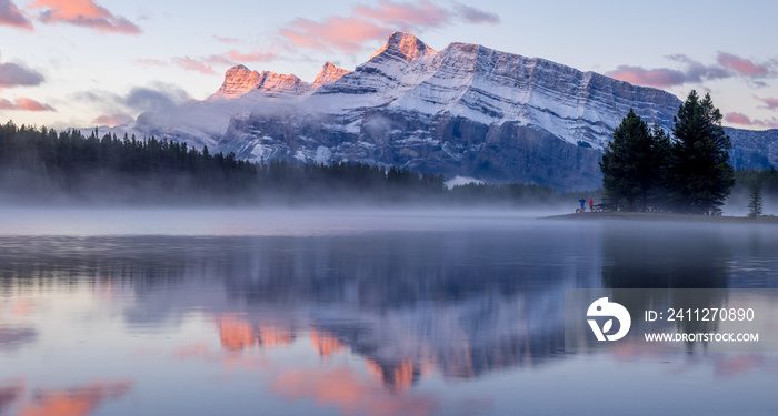 Rundle Mountain reflecting in Two Jack Lake in Banff National Park at sunrise.