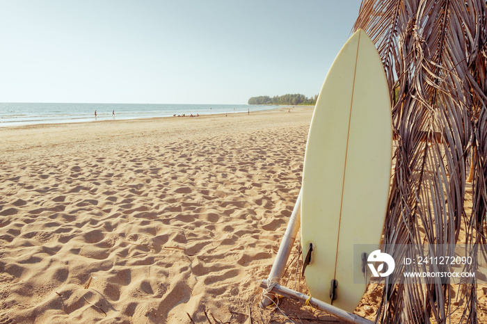 Surfboard on sand tropical beach with seascape calm sea and sky background. summer vacation background and water sport concept. vintage color tone effect.