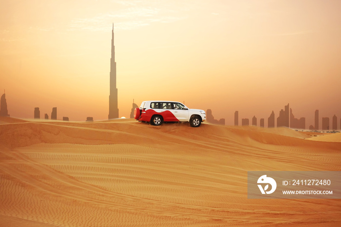 Off-road adventure with SUV in Arabian Desert at sunset with Dubai skyline or cityscape