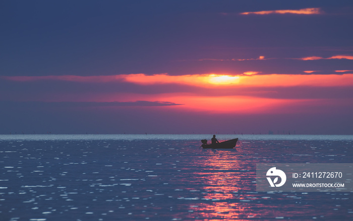 Silhouette fisherman on the boat in the sea.