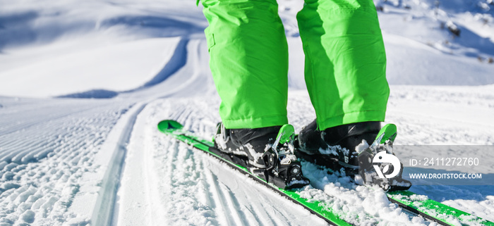 New groomed piste or slope. Lines in snow. Winter skis and detailed view of the ski bindings concept.