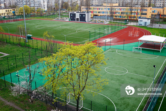 Open city sports grounds for playing football. Stadium, empty astro turf football field during lockdown in residential quarters, top view, sport concept in quarantine