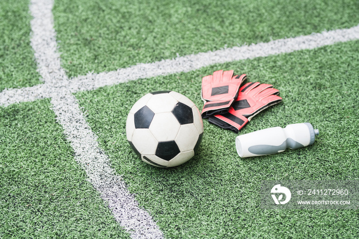 Group of sports gear - soccer ball, leather gloves and plastic bottle of water