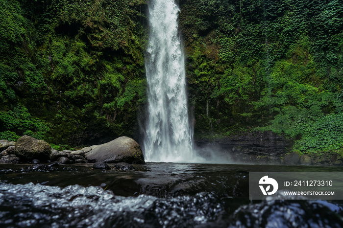 Secret waterfall deep in the jungle on Bali, Indonesia. Travel concept. Travel photography. Nungnung waterfall