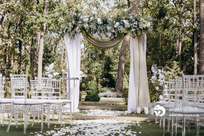 Elegant Wedding arch with fabric and flowers outdoors