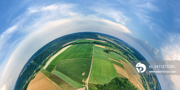 Aerial view from high altitude of little planet earth with green and yellow cultivated agricultural fields with growing crops on bright summer day