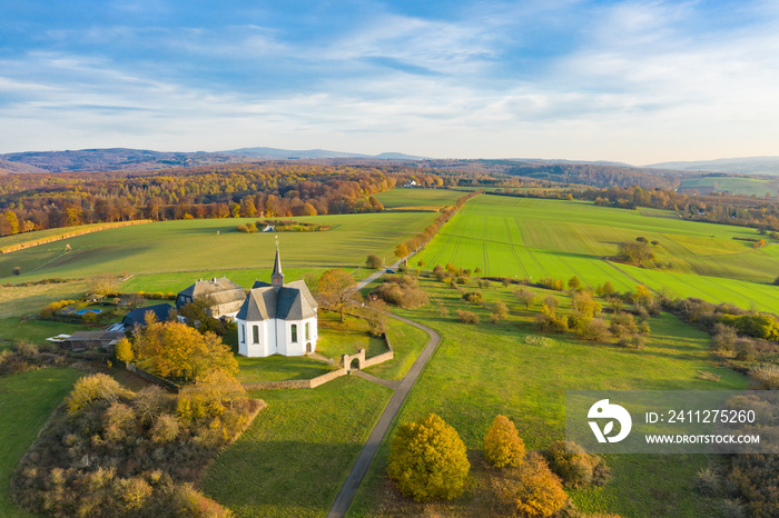 Bird’s eye view of the idyllic Kreuzkapelle near Bad Camberg / Germany in autumn in the warm evening light