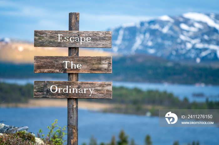 escape the ordinary text on wooden signpost outdoors in landscape scenery during blue hour and sunset.