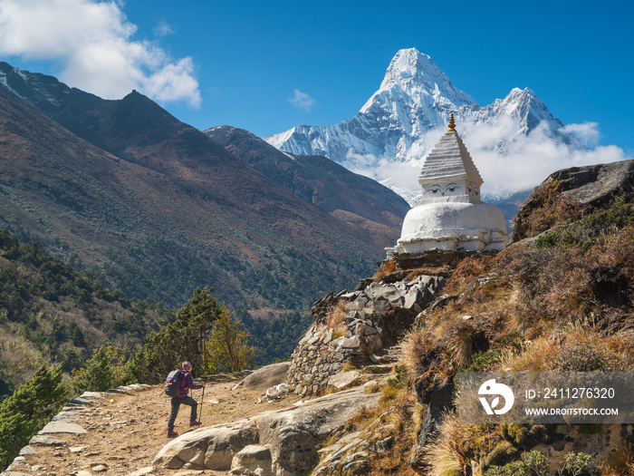 A girl trekking to buddha stupa with view to Ama Dablam peak in Nepal