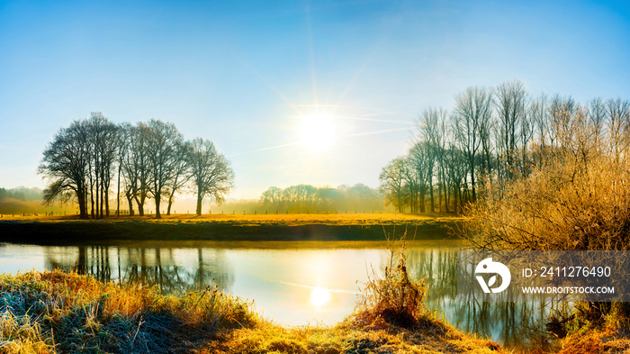 Landschaft mit Fluss bei Sonnenaufgang