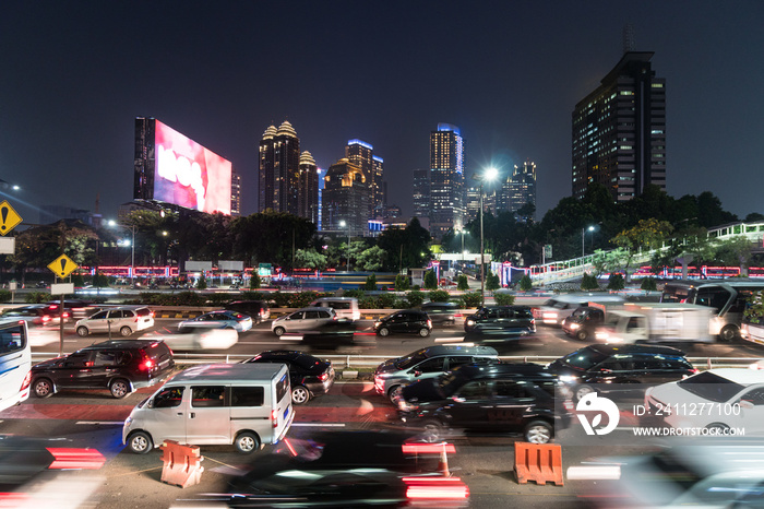 Traffic captured with blurred motion in the modern Jakarta downtown district along a crowded highway at night rush hour in Jakarta, Indonesia capital city