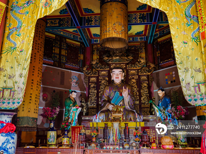 Elaborately carved and decorated statue of Buddha at a Taoist temple in Hainan, China