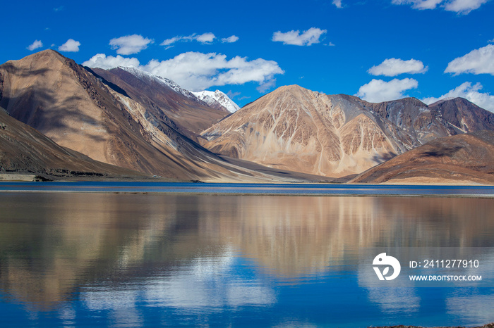 View of majestic rocky mountains against the blue sky and lake Pangong in Indian Himalayas, Ladakh region, India. Nature and travel concept