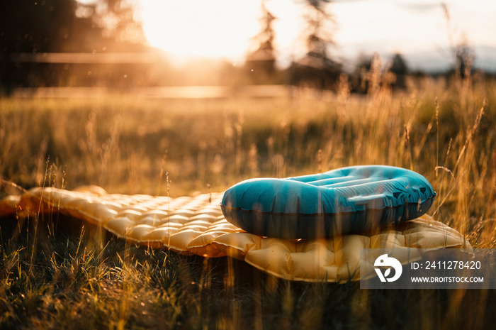 Woman relaxing and lie in a sleeping bag in the tent. Sunset camping in forest. Mountains landscape travel lifestyle camping. Summer travel outdoor adventure