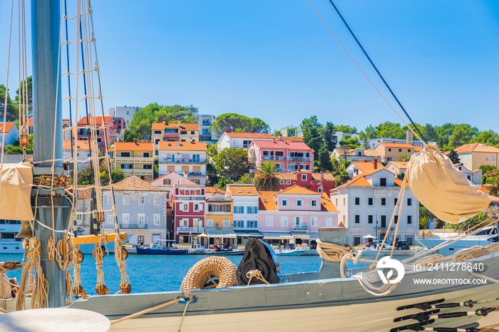 Old traditional wooden ships in the harbor in town of Mali Losinj on the island of Losinj, Adriatic coast, Croatia, cityscape and seafront in background