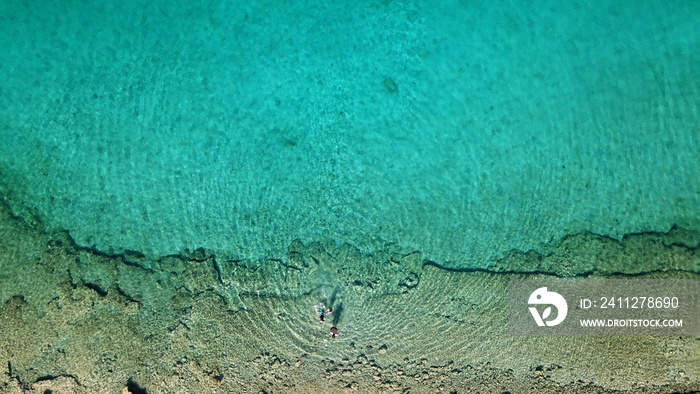 Aerial drone bird’s eye view photo from turquoise clear water seascape in island of Shinousa or Schinoussa, Cyclades, Greece