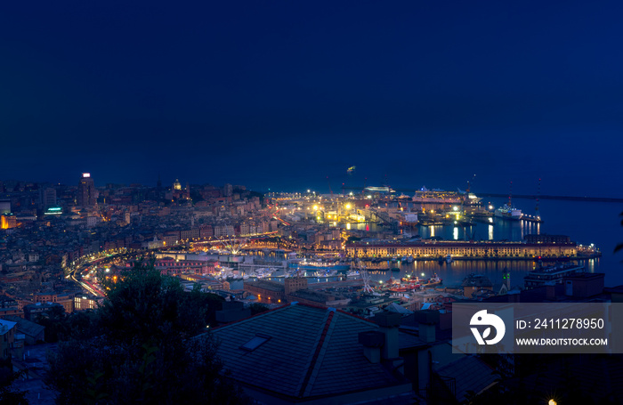 Night cityscape of Genova with the old port, cruise ships, sea and port cranes in the background