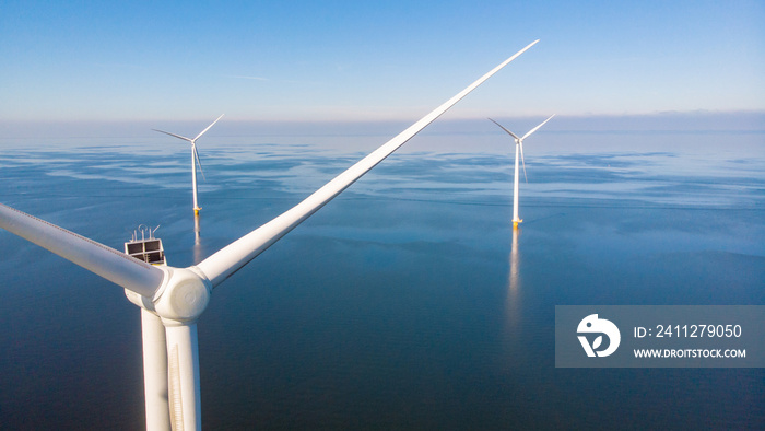 Windmill farm in the ocean Westermeerwind park, windmills isolated at sea on a beautiful bright day Netherlands Flevoland Noordoostpolder. Huge windmill turbines