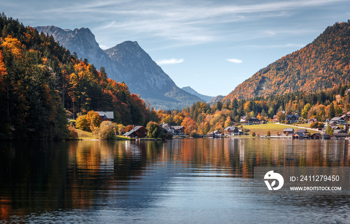 Scenic panorama of beautiful alpine autumn view with lake, mountains, green meadow and perfect sky. Amazing nature scenery. Wonderful sunny landscape. Grundlsee. Austria