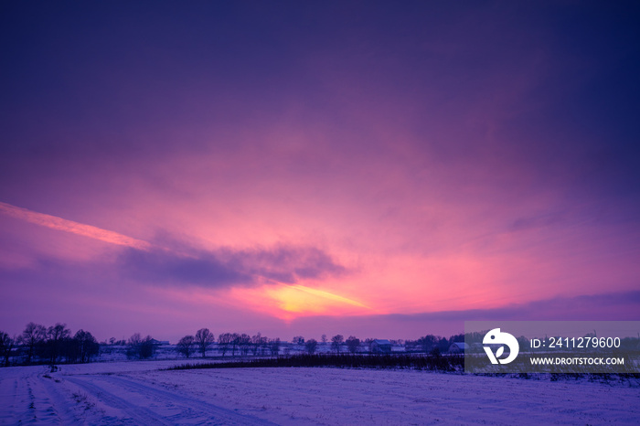 Field covered with snow at sunset