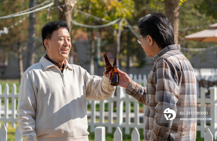 两个老年男人站在露营地喝啤酒