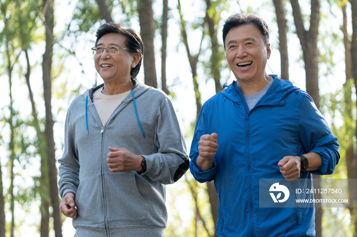 两个戴运动手表的中老年男人在树林跑步健身