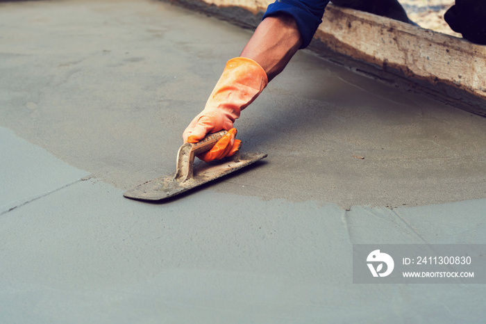 worker leveling concrete pavement for mix cement at construction site