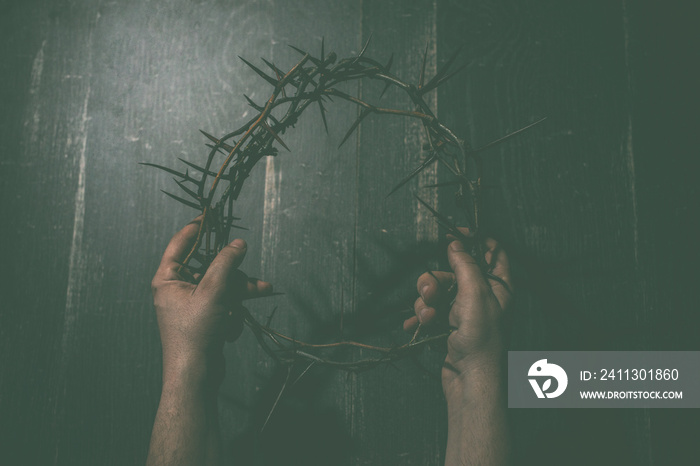 two hands hold crown of thorns