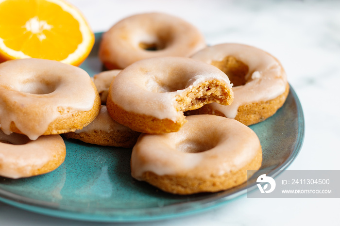 Home made baked whole wheat vegan donuts with orange glaze