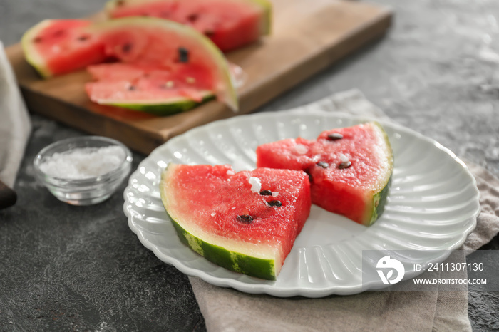 Plate with slices of watermelon on grunge background