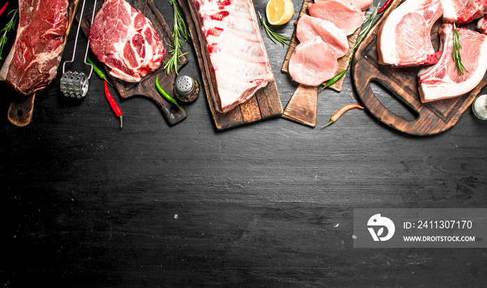 Different types of raw pork meat and beef with herb and spices.