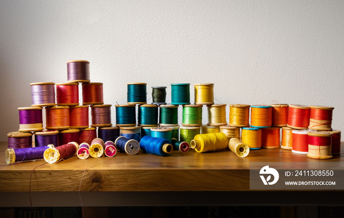 Collection of vintage cotton reels arranged in the colour spectrum